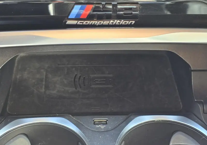 Détail de la console centrale du BMW Série 8 Cabriolet M8 Competition 2021 avec badge M8 et zone de recharge sans fil.