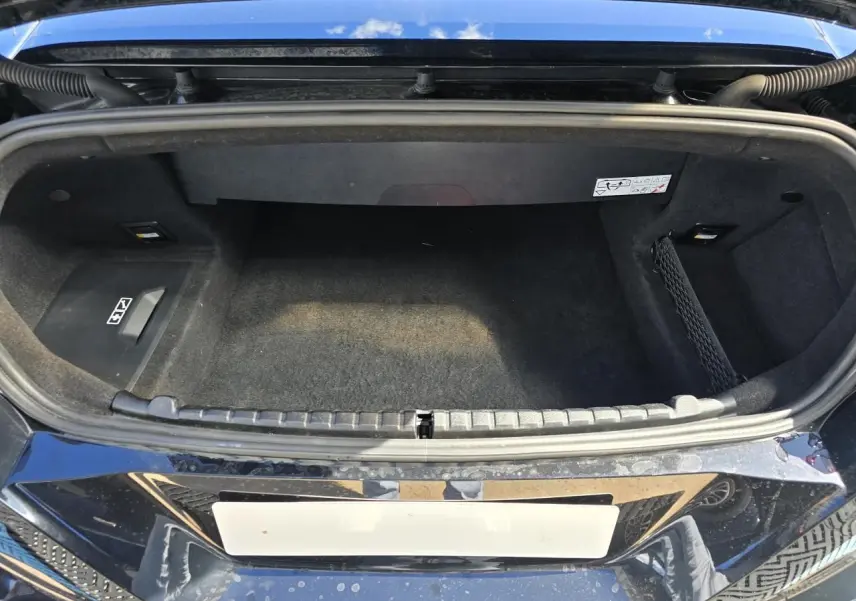 Coffre ouvert vu de dessus de la BMW Série 8 Cabriolet M8 Competition noir saphir métallisé, intérieur tissu noir.