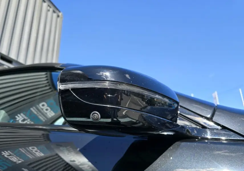 Gros plan sur le rétroviseur droit noir brillant avec caméra intégrée d'une BMW Série 8 Cabriolet M8 Competition noir saphir métal.