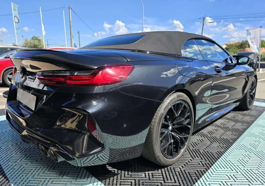 BMW Série 8 Cabriolet M8 Competition noir saphir métal vue 3/4 arrière droit avec capote fermée et jantes noires.