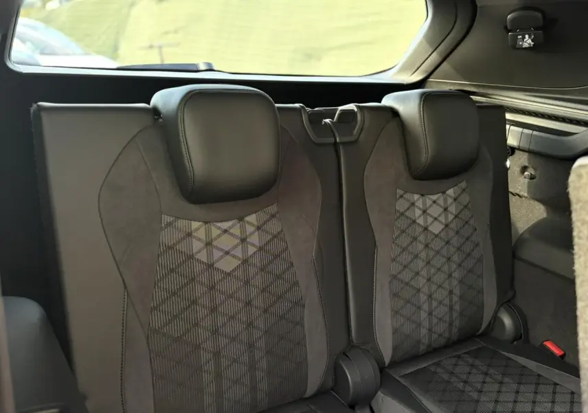 Vue intérieure sur la troisième rangée de sièges en cuir noir et tissu gris du Volkswagen Tayron 2025.