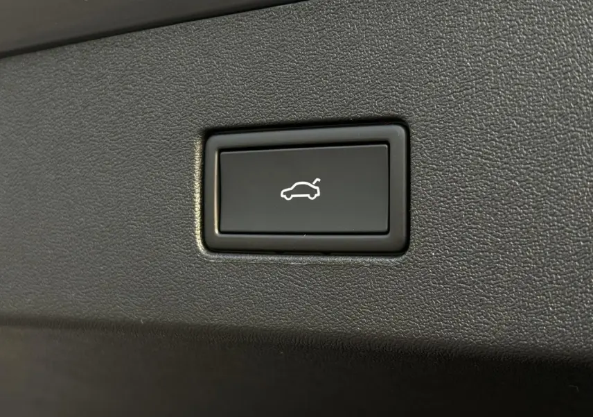 Bouton noir d'ouverture électrique du hayon sur Volkswagen Tayron gris dauphin, vue rapprochée intérieure.