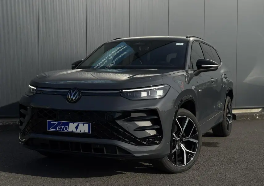 Volkswagen Tayron gris dauphin en 3/4 avant droit avec jantes alliage 20 pouces et calandre noire R-Line.
