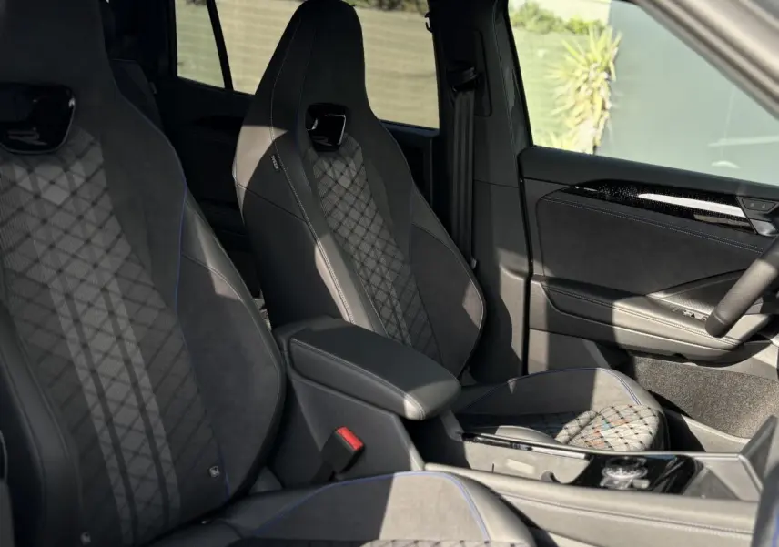 Vue intérieure côté droit du Volkswagen Tayron 2.0 TDI R-Line 7 places, sièges sport noirs avec surpiqûres bleues et détails en alcantara.