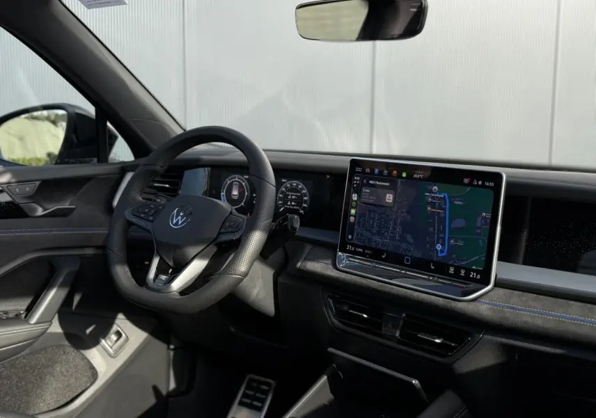 Vue intérieure côté conducteur du Volkswagen Tayron 2025, tableau de bord noir avec écran tactile et volant multifonction.