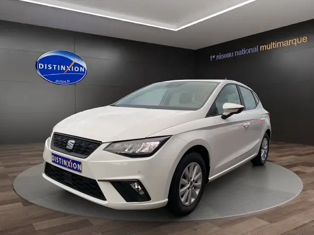 SEAT Ibiza 1.0 MPI 80 STYLE blanc candy vue 3/4 avant droit en showroom avec jantes alliage et phares LED.