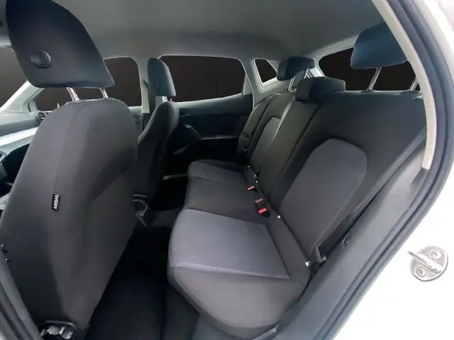 Vue intérieure arrière du siège arrière gris foncé d'une SEAT IBIZA 1.0 MPI 80 STYLE blanc candy 2023 avec porte ouverte côté droit.