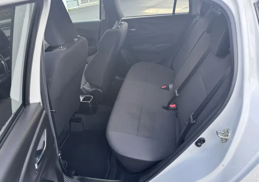 Vue intérieure côté droit montrant la banquette arrière noire d'une Suzuki Swift 1.2 Privilège blanche 2025 avec porte ouverte.