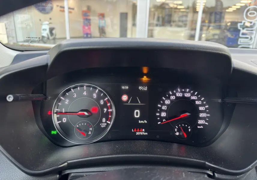 Tableau de bord de Suzuki Swift 1.2 Privilège 2025, affichage numérique et compteurs analogiques allumés, vue frontale intérieure.