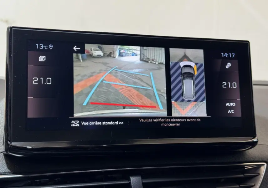 Écran tactile du tableau de bord du Peugeot 3008 gris clair montrant la caméra de recul et l'aide au stationnement arrière.