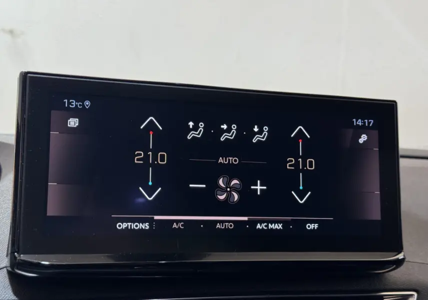 Écran tactile central affichant la climatisation à 21°C dans le Peugeot 3008 GT gris clair, vue intérieure rapprochée.