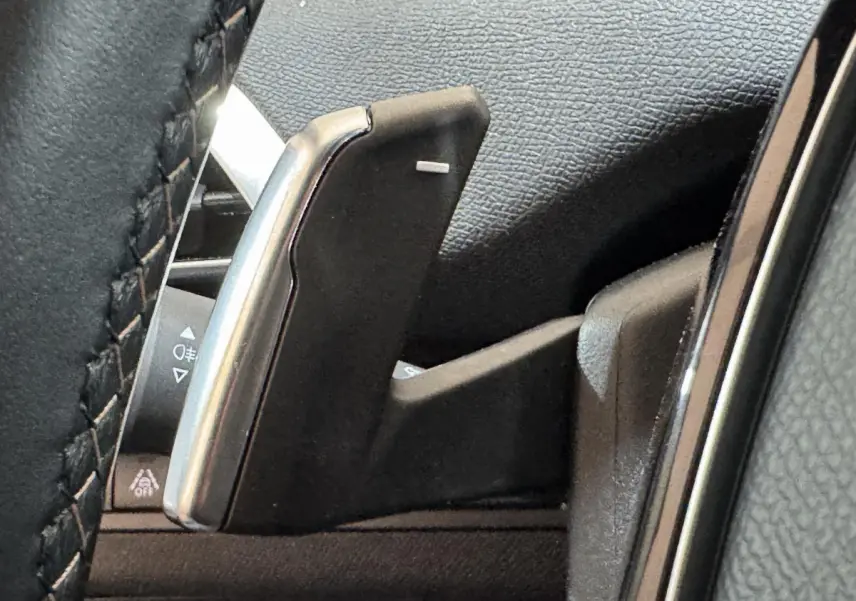 Gros plan sur la palette de changement de vitesse noire et argentée du volant du Peugeot 3008 GT gris clair.