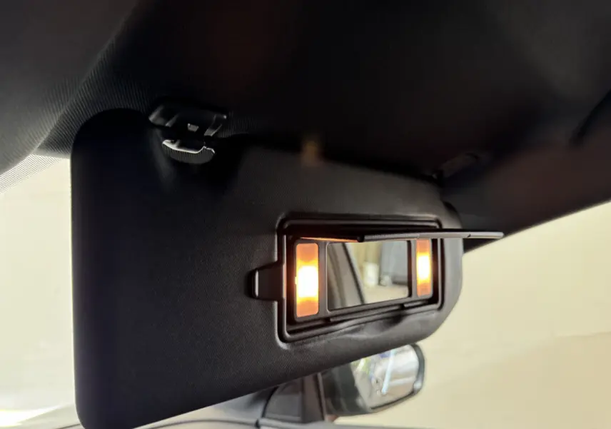 Miroir de courtoisie éclairé sur pare-soleil côté conducteur dans l'habitacle du Peugeot 3008 gris clair 2021.