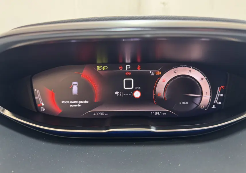 Tableau de bord numérique du Peugeot 3008 GT 2021 avec affichage de vitesse, compte-tours et alerte porte avant gauche ouverte.