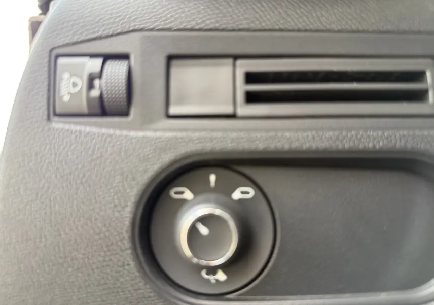 Gros plan sur la commande des rétroviseurs et la molette de réglage d’éclairage dans l’habitacle d’une DS3 hybride gris Artense.