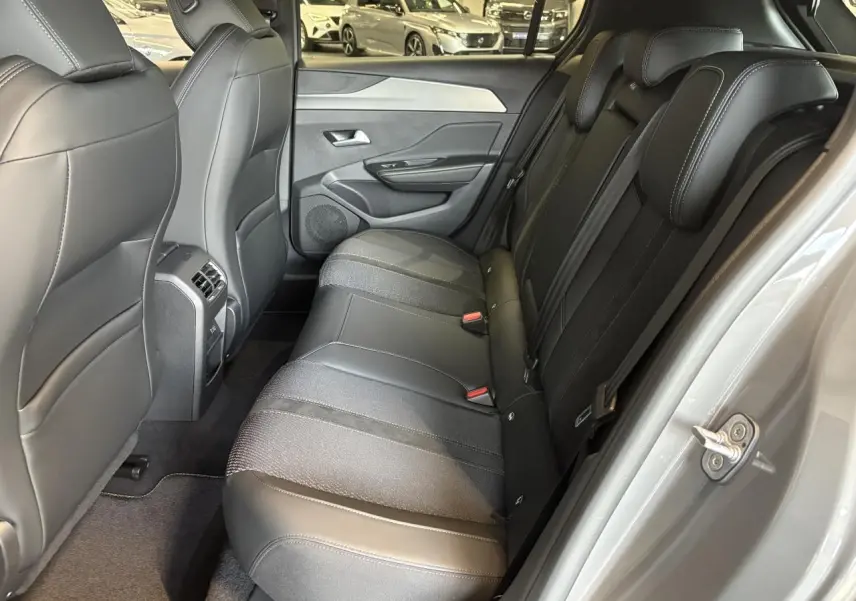 Vue intérieure côté droit des sièges arrière noirs en tissu et cuir dans une Peugeot 308 gris selenium 2025.