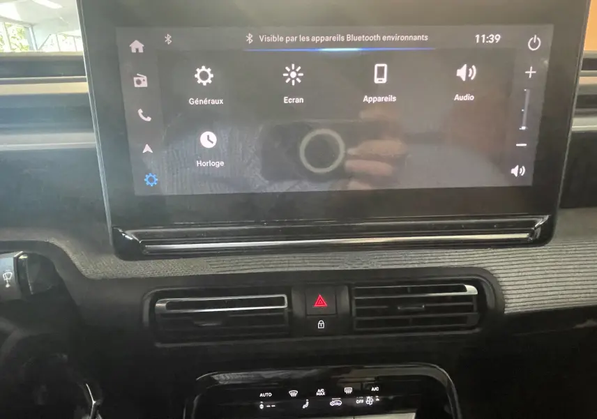 Vue rapprochée de l’écran tactile 10 pouces et de la console centrale du tableau de bord de la Citroën E-C3 113 MAX noire 2025.