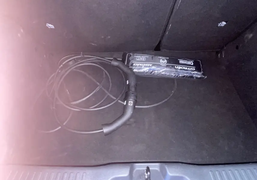 Coffre noir de Citroën E-C3 113 MAX 2025 avec câble de recharge électrique et trousse d'assistance visible.