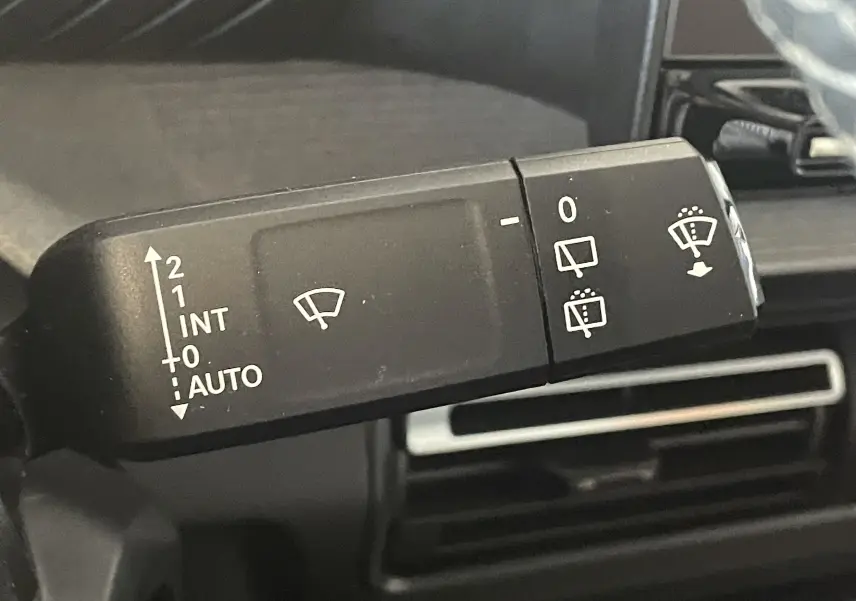 Gros plan sur la commande des essuie-glaces du Citroën E-C3 113 MAX 2025, intérieur noir avec détails blancs.