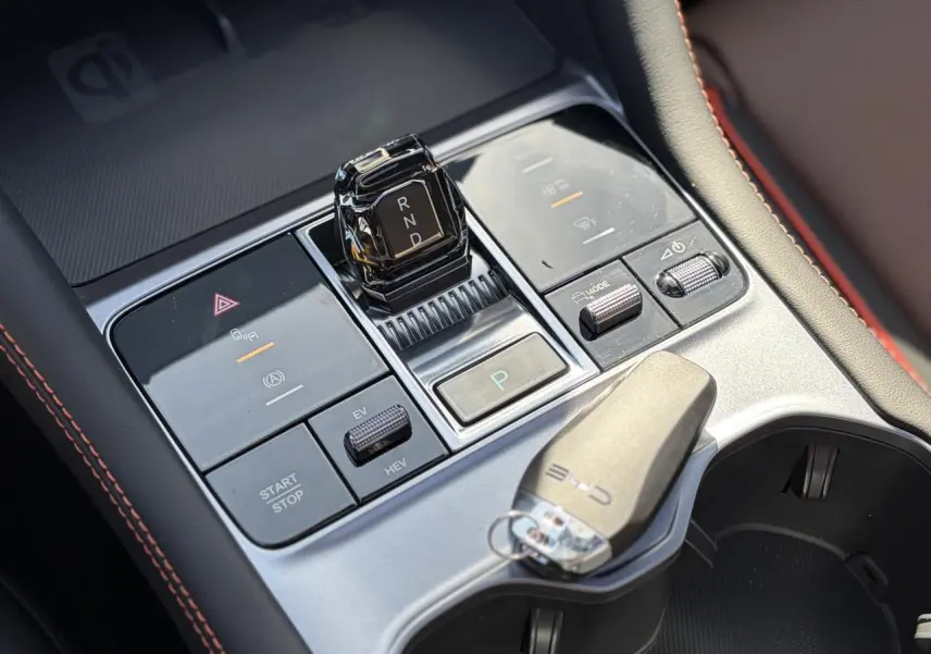 Vue rapprochée de la console centrale du BYD SEAL U 2025, avec levier de vitesses cristal et clé posée, finition noire et brun.