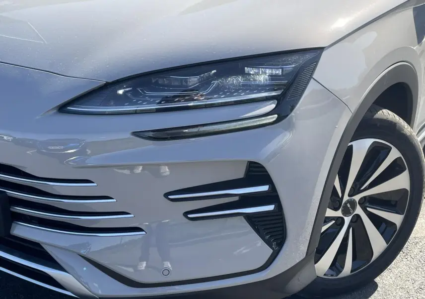 Gros plan sur l'avant droit du BYD SEAL U 2025 en peinture métallisée Boundless Cloud beige avec phares LED et jante bicolore.