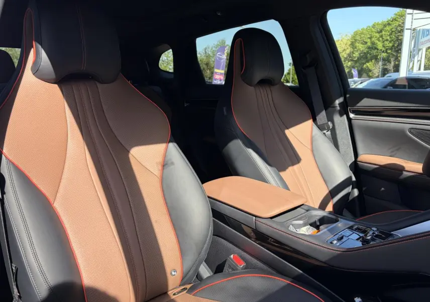Vue intérieure des sièges avant en similicuir noir et brun avec surpiqûres rouges du BYD SEAL U 2025.