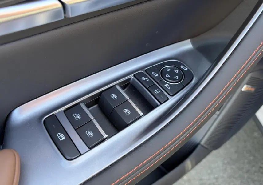 Gros plan sur les commandes des vitres et rétroviseurs côté conducteur du BYD SEAL U 2025 en intérieur noir et brun.