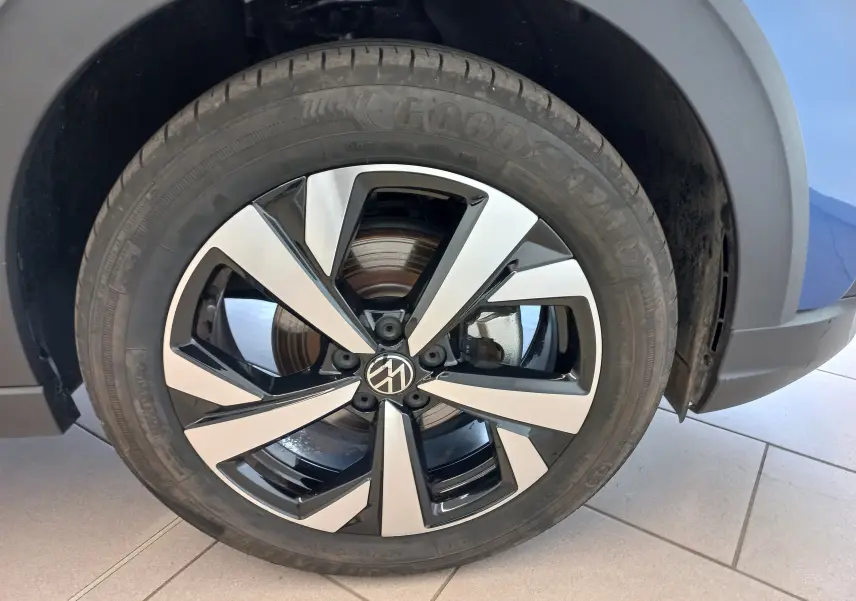 Gros plan sur la jante alliage 17 pouces Aberdeen bicolore du Volkswagen Taigo bleu récif, côté avant droit.