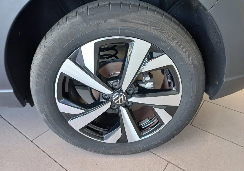Gros plan sur la jante alliage 17 pouces Aberdeen bicolore noir et argent du Volkswagen Taigo bleu récif, roue avant droite.