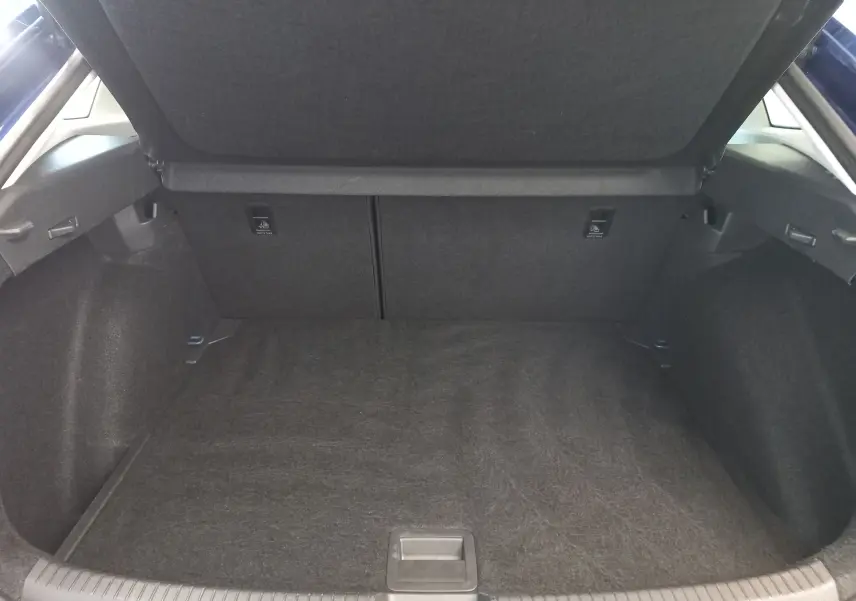 Coffre ouvert vu de l'arrière d'un Volkswagen Taigo 2025 bleu récif, montrant un espace de chargement propre et spacieux.