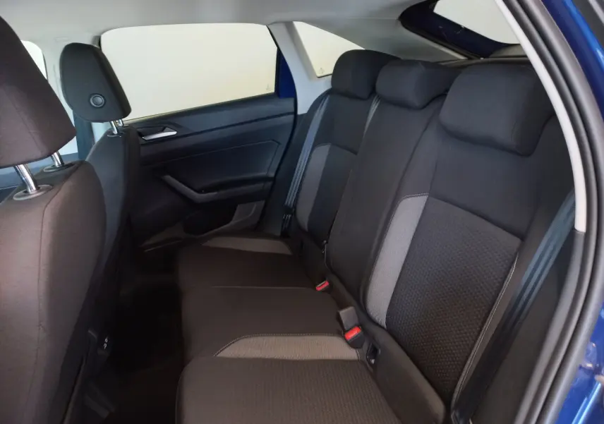 Vue intérieure côté droit des sièges arrière noirs du Volkswagen Taigo 2025 bleu récif avec appuie-têtes et ceintures visibles.