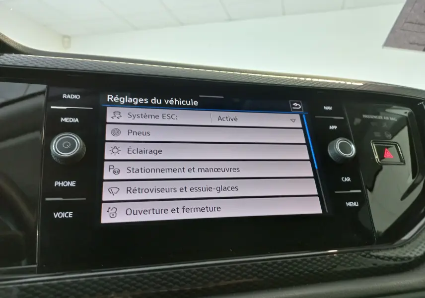 Écran tactile central du Volkswagen Taigo 2025 affichant les réglages du véhicule dans un intérieur noir.