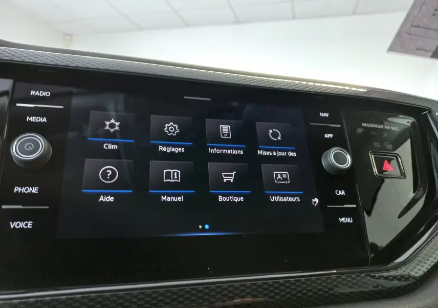 Écran tactile central du tableau de bord du Volkswagen Taigo 2025, affichant le menu des réglages et aides.