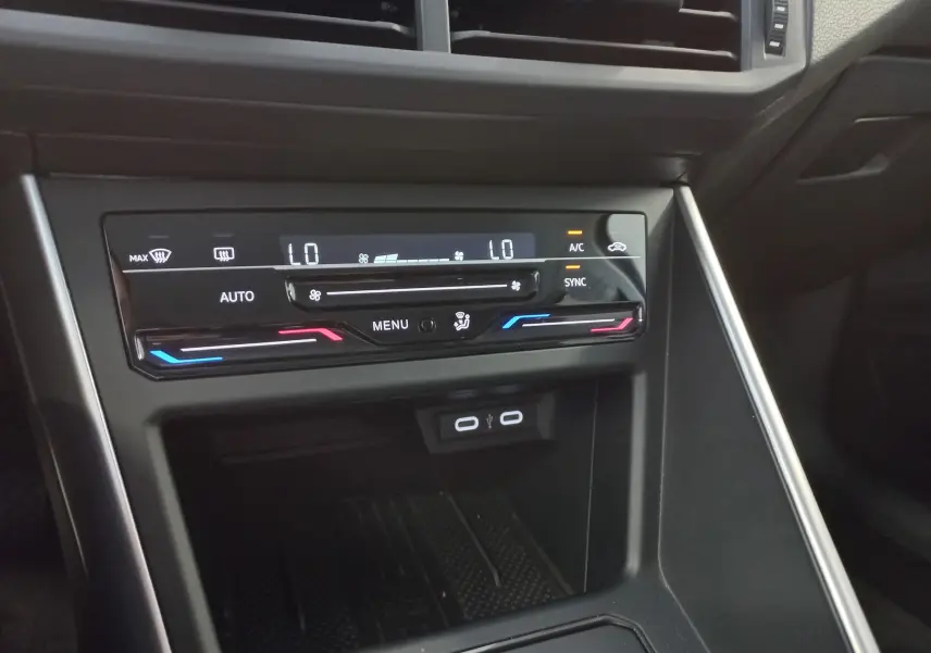 Gros plan sur la console centrale du Volkswagen Taigo 2025, affichant la climatisation automatique bi-zone tactile.