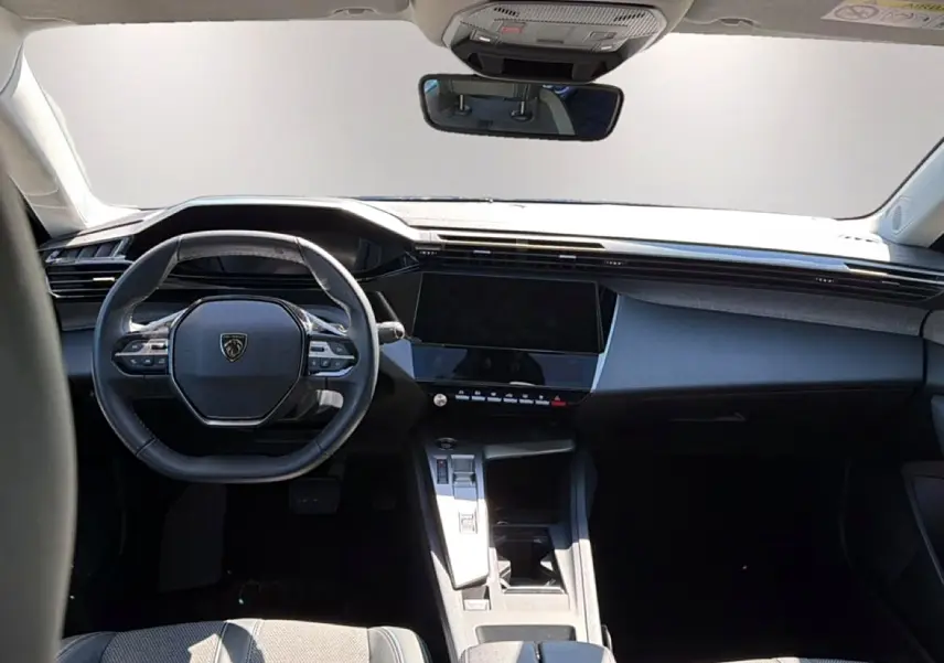 Vue intérieure frontale du tableau de bord et volant cuir noir de la Peugeot 408 Hybrid 145 allure e-dcs6 2025.