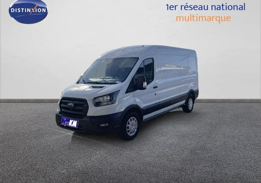 Fourgon Ford Transit blanc vu en 3/4 avant droit, avec carrosserie haute et longue, stationné devant un mur clair.