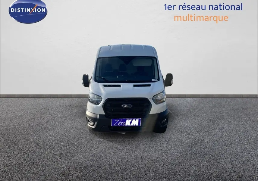 Vue frontale d'un fourgon Ford Transit blanc 2023 avec calandre noire et rétroviseurs latéraux visibles.