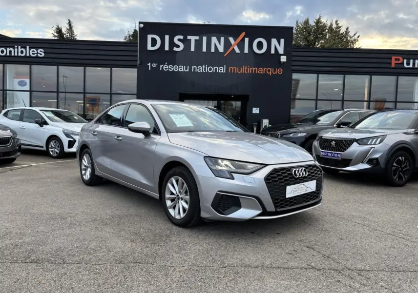 Audi A3 berline argent métallisé vue 3/4 avant, avec calandre hexagonale noire et jantes alliage 5 branches.