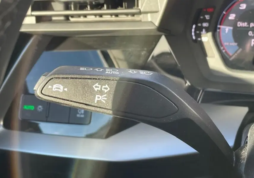 Gros plan sur la commande de clignotant et d'aide au stationnement dans l'Audi A3 argent fleuret 2022.