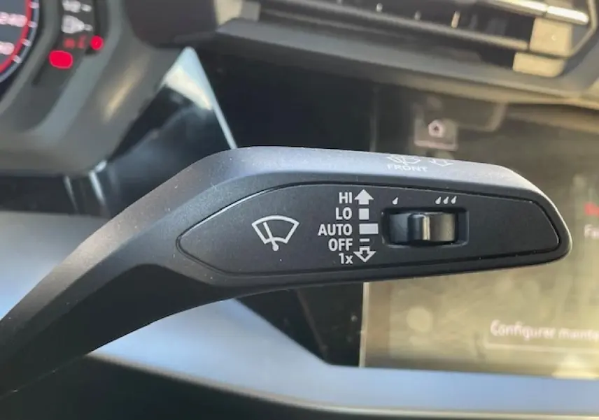 Gros plan sur la commande de l'essuie-glace dans l'habitacle de l'Audi A3 IV Berline 30 TFSI MHEV argent fleuret métal.