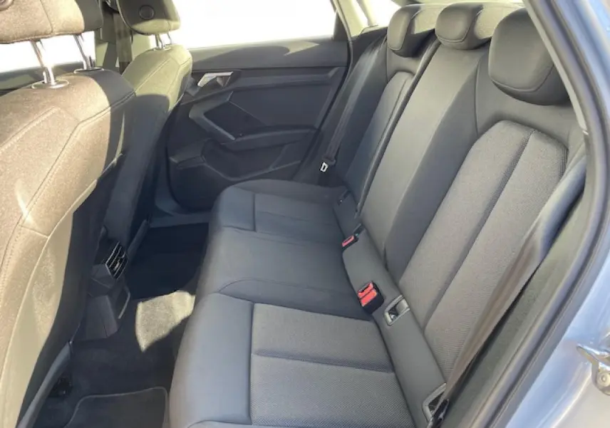 Vue latérale droite de l'habitacle arrière de l'Audi A3 2022 avec sièges tissu gris et ceintures de sécurité visibles.