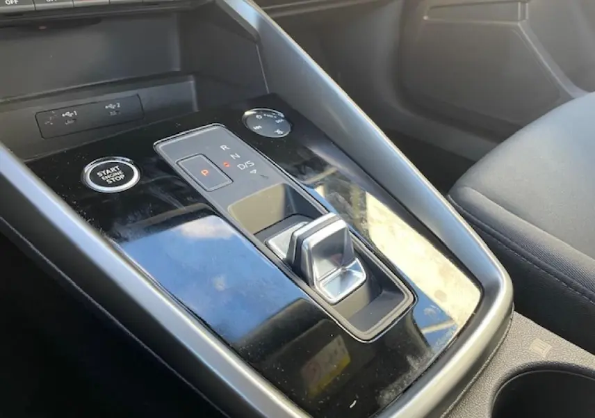 Gros plan sur la console centrale noire brillante avec levier de vitesses et bouton start/stop de l'Audi A3 argent fleuret 2022