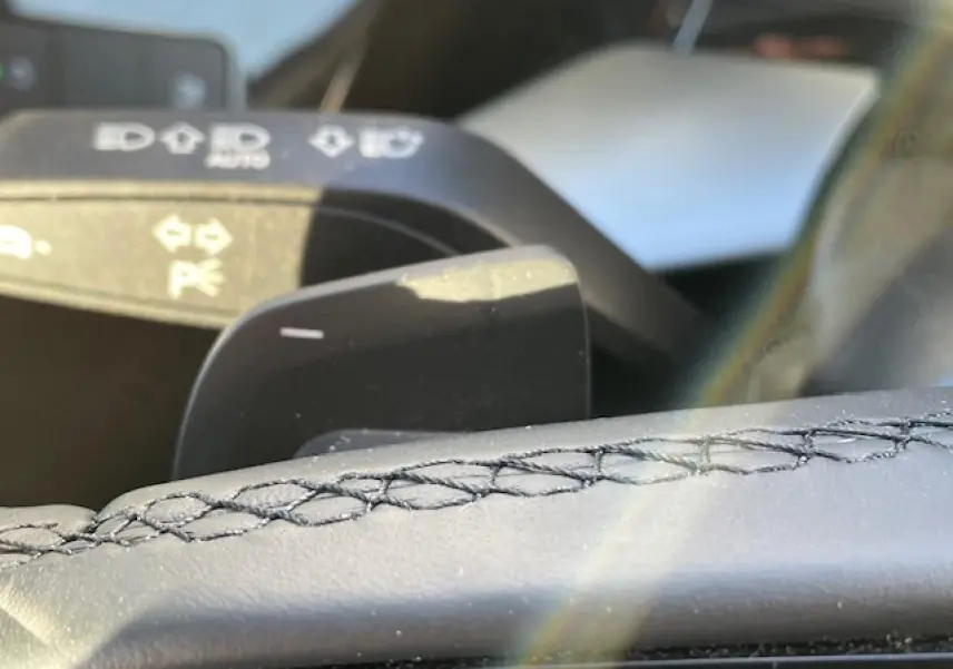 Gros plan sur la palette de changement de vitesses et le volant cuir noir de l'Audi A3 IV Berline 2022.