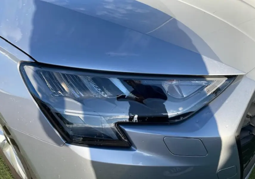 Gros plan sur le phare avant droit argenté de l'Audi A3 IV Berline 30 TFSI MHEV 2022 avec peinture métallisée.