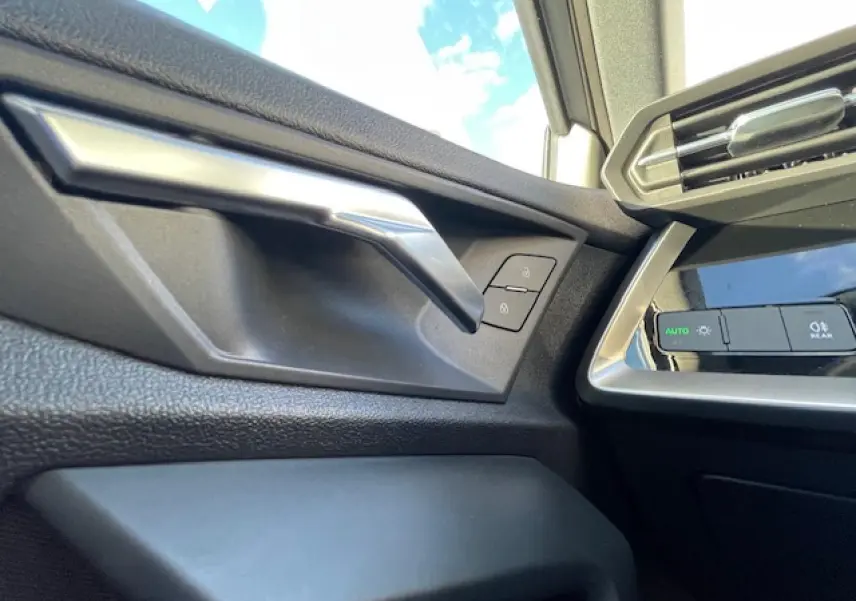 Poignée de porte côté gauche et commandes d’éclairage intérieur de l’Audi A3 IV Berline 2022, finition argent métallisé.