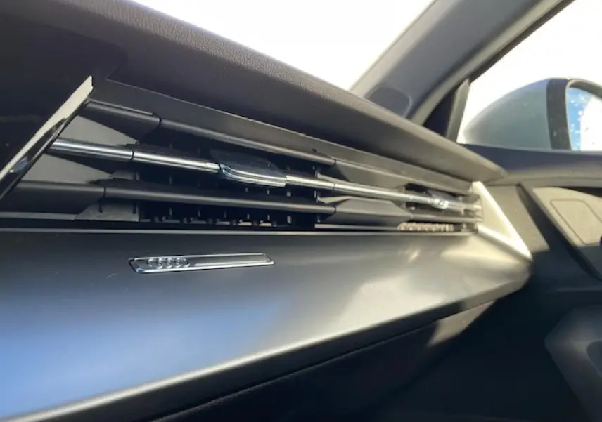 Détail de la sortie d'air chromée côté passager de l'habitacle de l'Audi A3 IV Berline argent métallisé 2022.