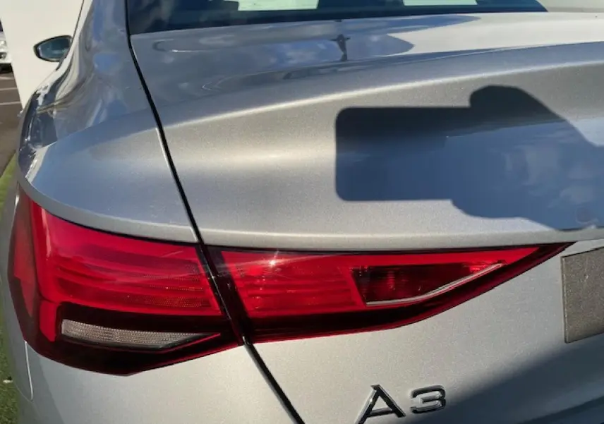 Gros plan sur le feu arrière gauche argenté métallisé d'une Audi A3 IV Berline 2022, soulignant ses lignes nettes.