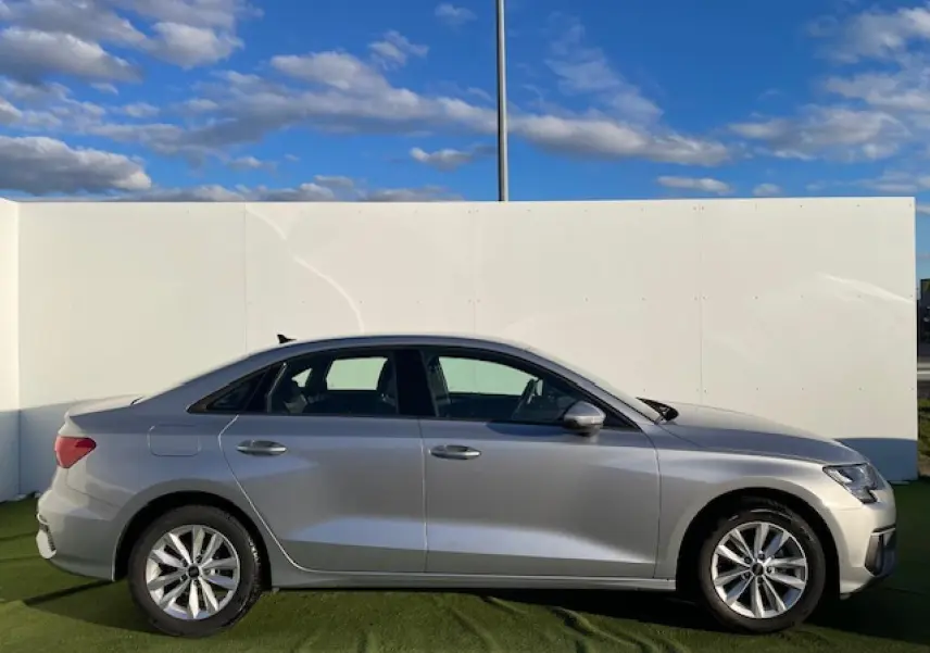 Profil côté gauche d'une Audi A3 berline 2022 argent métallisé avec jantes alliage 5 branches parallèles.