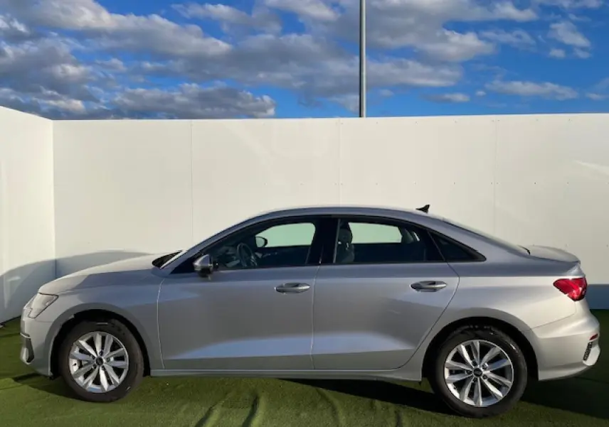 Profil côté gauche d'une Audi A3 berline 2022 argent métallisé, avec jantes alliage et lignes épurées.