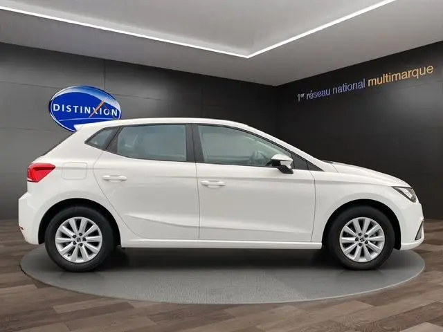Profil côté gauche d'une SEAT IBIZA 1.0 MPI 80 STYLE blanche Candy, 5 portes, dans un showroom moderne.